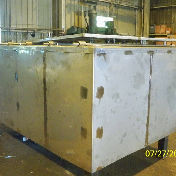 Worker beside a massive fabricated steel structure on site, giving a sense of project scale