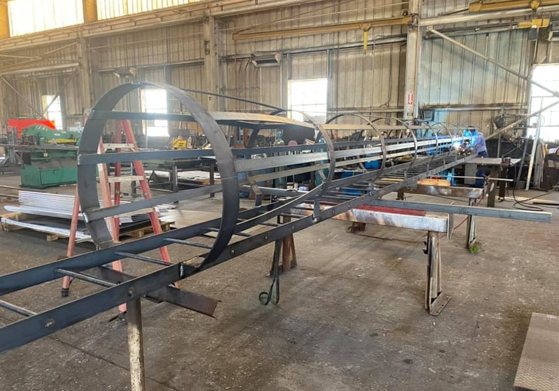 Large steel ship's ladder with diamond-plate treads and pipe railings being fabricated at A&K Machine & Fabrication