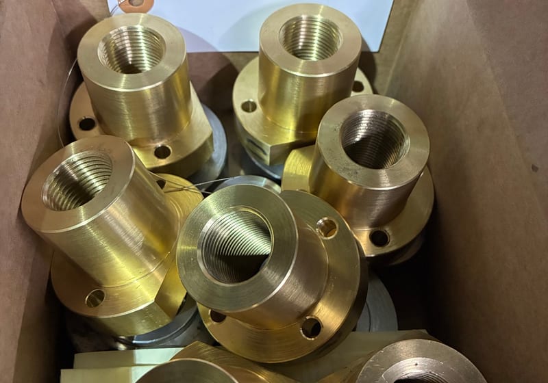 Box of large brass/bronze finished bushings — A&K Machine & Fabrication, Jacksonville FL