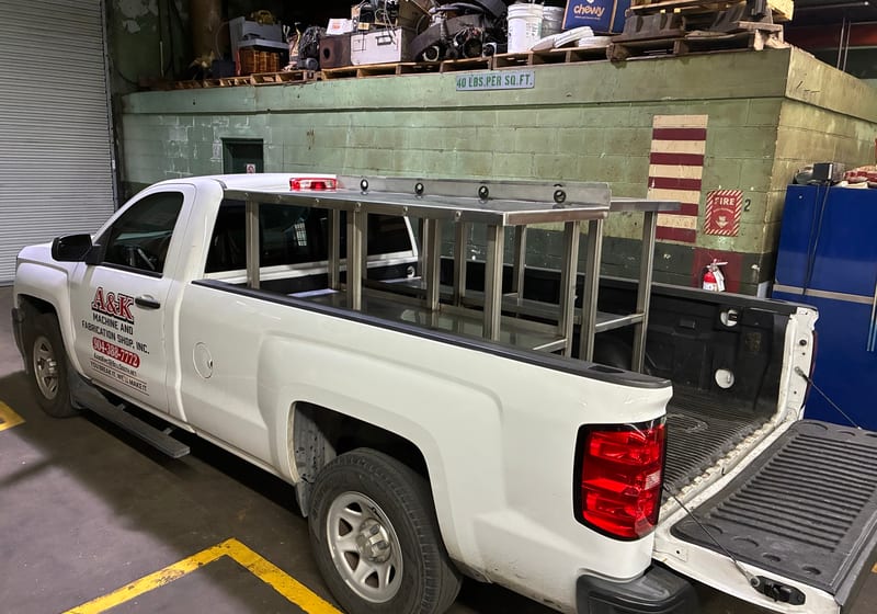 A&K branded white pickup truck with custom welded ladder rack - corporate identity shot — A&K Machine & Fabrication, Jacksonville FL