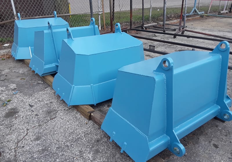 Row of bright blue painted industrial buckets/clamshells (JEA-style) — A&K Machine & Fabrication, Jacksonville FL