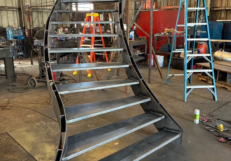 Complex spiral staircase being stood up during install — A&K Machine & Fabrication, Jacksonville FL