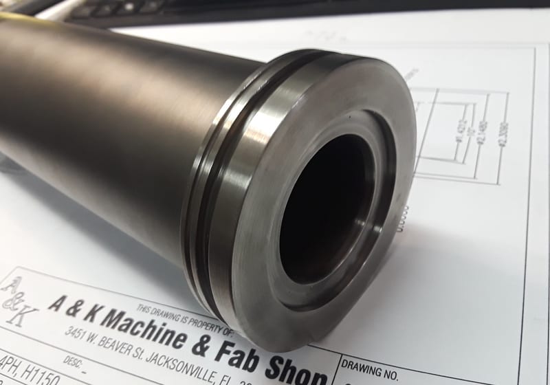 Same machined cylinder labeled with A&K Machine & Fab Shop card — A&K Machine & Fabrication, Jacksonville FL