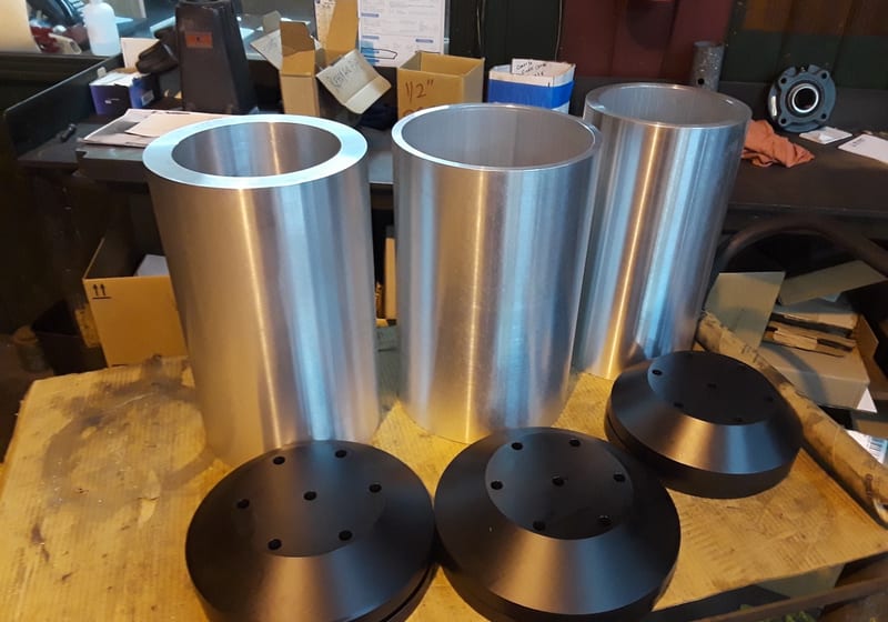 Three large machined hub housings stacked — A&K Machine & Fabrication, Jacksonville FL