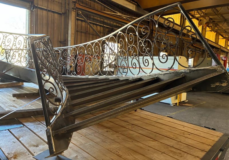 Ornate iron spiral staircase being fabricated/installed indoors — A&K Machine & Fabrication, Jacksonville FL