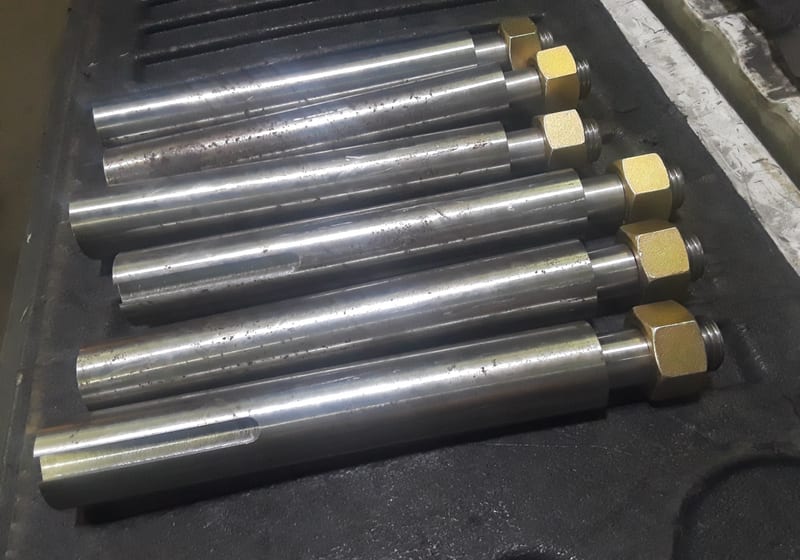 Row of machined shafts with tapered ends in case — A&K Machine & Fabrication, Jacksonville FL
