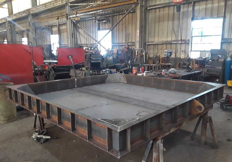 Worker fabricating a heavy table/frame in shop — A&K Machine & Fabrication, Jacksonville FL