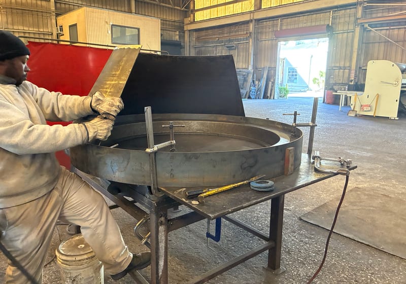 Worker fabricating large wok/bowl — A&K Machine & Fabrication, Jacksonville FL