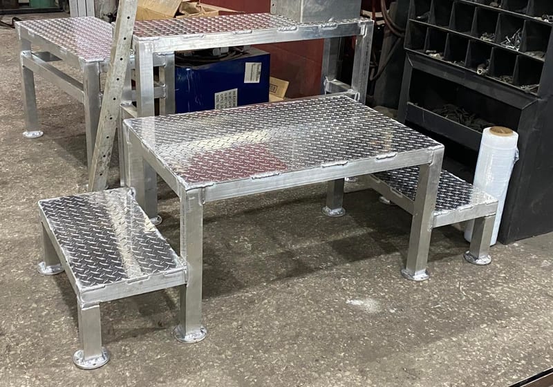 Set of three aluminum diamond-plate step platforms fabricated with welded legs at A&K Machine & Fabrication