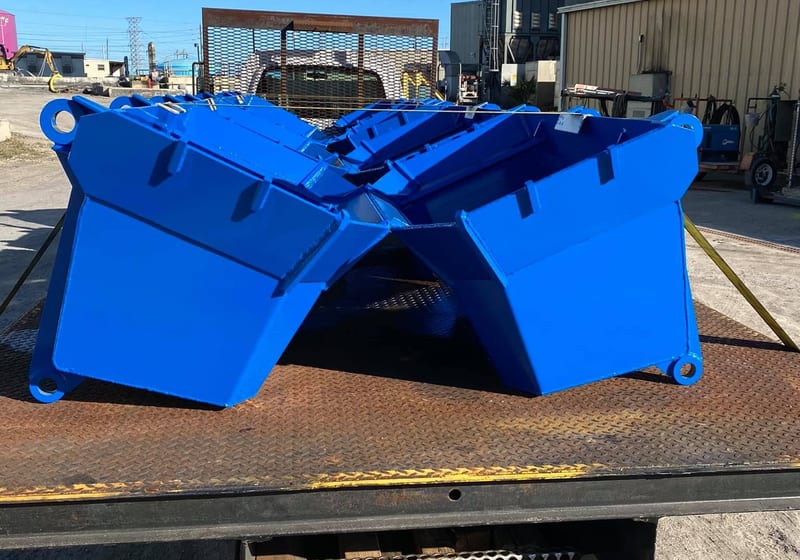Pair of bright blue painted industrial clamshell buckets fabricated for JEA by A&K Machine & Fabrication
