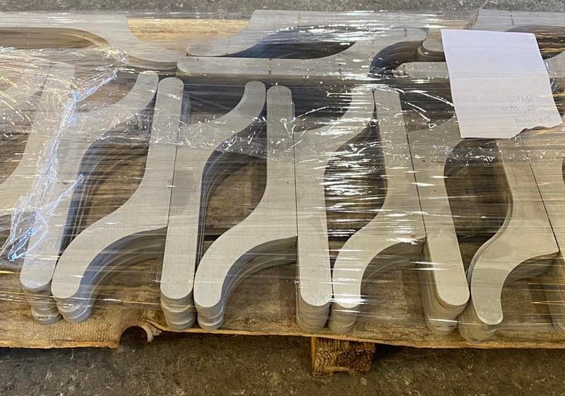 Batch of CNC-cut stainless steel spanner wrenches shrink-wrapped on pallet at A&K Machine & Fabrication