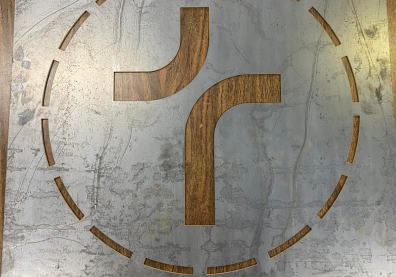 CNC plasma-cut metal sign panel with stylized logo design at A&K Machine & Fabrication