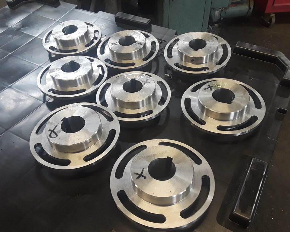Stack of machined cast-iron pulleys and sheaves in the A&K shop — A&K Machine & Fabrication, Jacksonville FL