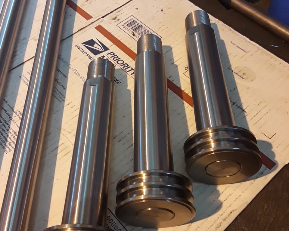 Multiple machined steel wheels and sheaves on the lathe table at A&K — A&K Machine & Fabrication, Jacksonville FL