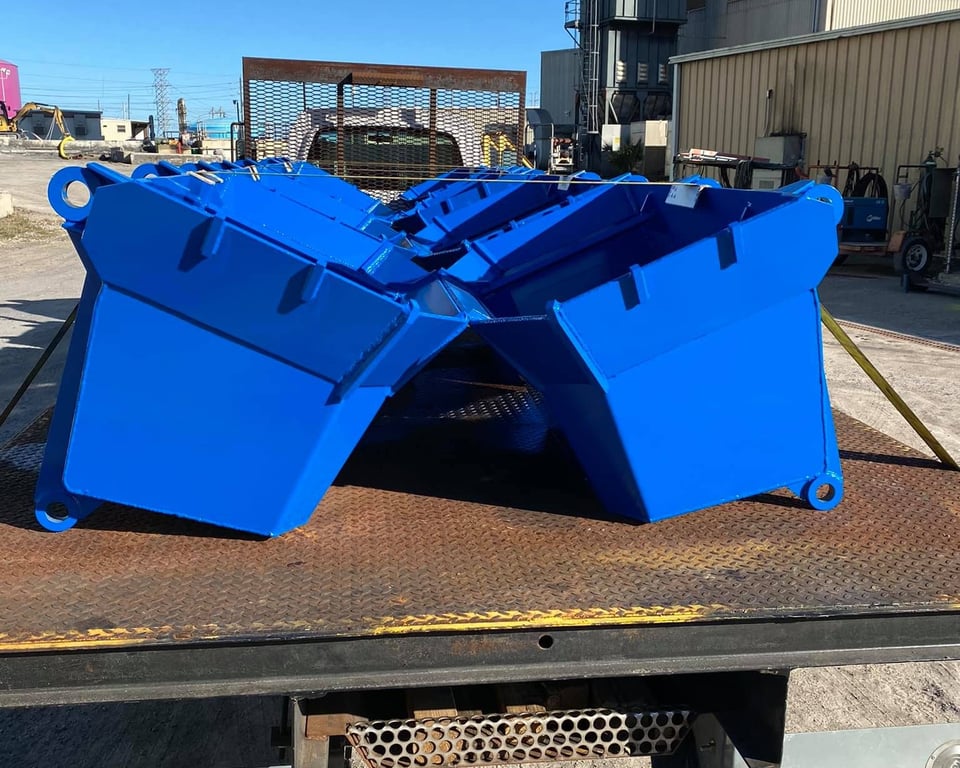 Pair of bright blue painted industrial clamshell buckets fabricated for JEA by A&K Machine & Fabrication